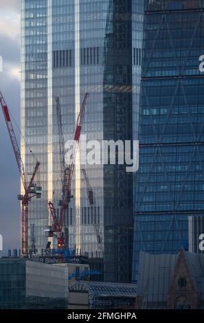 Glasverkleidungen von 22 Bishopsgate und 122 Leadenhall Street, The Cheesegrater, in der City of London, Mai 2021 mit Baukräne Stockfoto