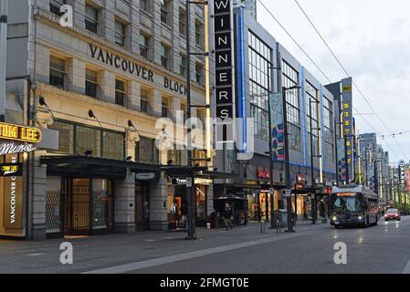 Ein Stadtbus und ein Taxi fahren in der Abenddämmerung in Vancouver, British Columbia, Kanada, die Granville Street entlang Stockfoto