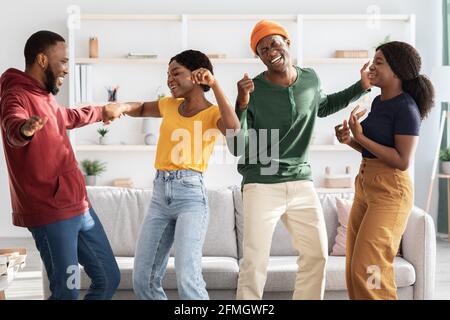 Lustige afroamerikanische Freunde, die zu Hause tanzen Stockfoto