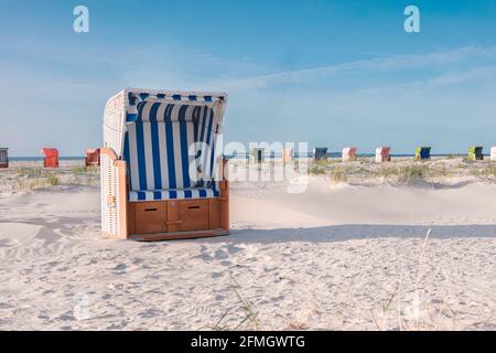 Mehrere überdachte Korbliegen am leeren Sandstrand an der Nordseeküste. Strandausrüstung in Ferienanlagen. Sommerurlaub, Urlaub am Meer Konzept Stockfoto