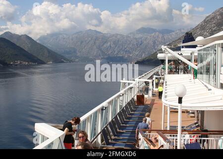 An Bord der Norwegian Star A Dawn-Klasse, die von Norwegian Cruise Line betrieben wird. Im Golf von Kotor, Montenegro mit Blick auf die Kalksteinfelsen des Mt. Lovćen. Stockfoto