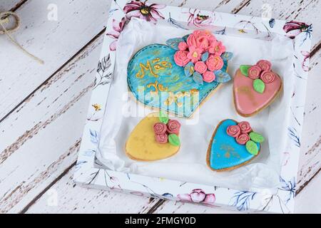 Butterige Kekse, dekoriert mit rollendem Fondant und königlicher Glasur. Geschrieben in portugiesischer Mutter, Ich liebe dich. Stockfoto