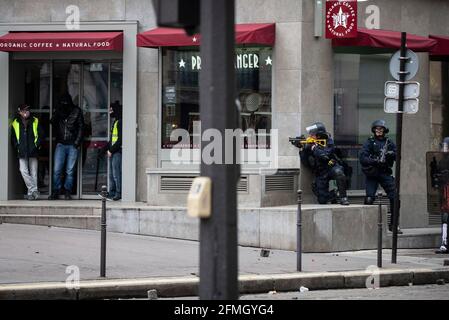 Polizisten stehen bei Zusammenstößen mit Demonstranten in der Nähe bereit Der Arc de Triomphe während des vierten Samstag der nationalen Proteste der „Gelben Stockfoto