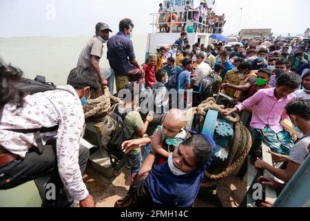 Manikganj, Bangladesch. Mai 2021. Die Menschen in Bangladesch versuchen, an Bord einer überfüllten Fähre zu gehen, um ihre Dorfhäuser für das Eid al-Fitr-Festival in Paturiya, Manikganj, am Stadtrand von Dhaka, Bangladesch, am 9. Mai 2021 zu besuchen. Im Vorfeld des muslimischen Eid al-Fitr-Festivals herrschte nun aus den Städten und Städten Bangladeschs ein verrückter Ansturm auf Eid-Heimgänger, obwohl die Regierung alle aufforderte, an ihren derzeitigen Orten zu bleiben, um die Ausbreitung des COVID-19 zu begrenzen. Quelle: Suvra Kanti das/ZUMA Wire/Alamy Live News Stockfoto