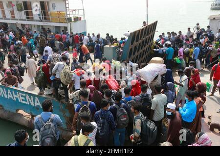Manikganj, Bangladesch. Mai 2021. Die Menschen in Bangladesch versuchen, an Bord einer überfüllten Fähre zu gehen, um ihre Dorfhäuser für das Eid al-Fitr-Festival in Paturiya, Manikganj, am Stadtrand von Dhaka, Bangladesch, am 9. Mai 2021 zu besuchen. Im Vorfeld des muslimischen Eid al-Fitr-Festivals herrschte nun aus den Städten und Städten Bangladeschs ein verrückter Ansturm auf Eid-Heimgänger, obwohl die Regierung alle aufforderte, an ihren derzeitigen Orten zu bleiben, um die Ausbreitung des COVID-19 zu begrenzen. Quelle: Suvra Kanti das/ZUMA Wire/Alamy Live News Stockfoto