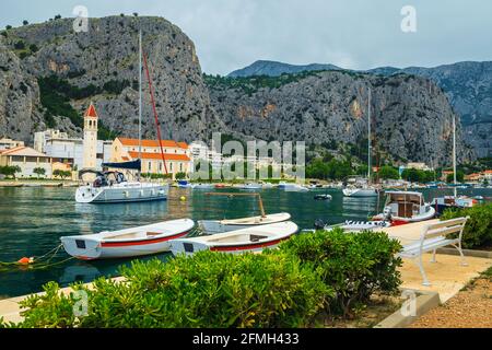 Angel- und Segelboote auf dem Fluss Cetina in Omis Resort. Verankerte Boote und hohe Berge im Hintergrund, Omis, Makarska riviera, Dalmatien, Kroatien Stockfoto