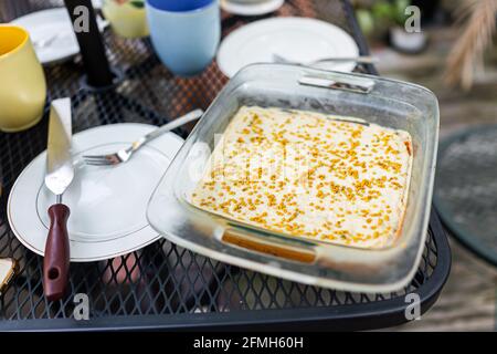 Gelbe Vanillecreme Dessert hausgemachte Karottenkuchen auf Outdoor-Metall Tisch mit Bienenpollen-Verzierungen und leerer Platte über Ansicht Stockfoto