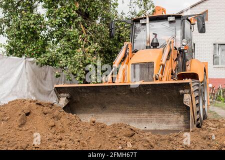 Bagger oder Planierraupen ebnen den Boden oder die Straße Die Industriezone oder Baustelle Stockfoto