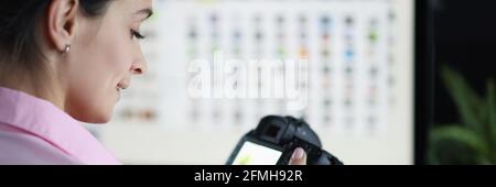 Junge Frau, die Kamera in den Händen hält und Fotos ansieht Stockfoto