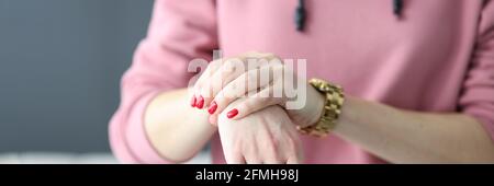 Frau mit roter Maniküre hält ihr Handgelenk Nahaufnahme Stockfoto