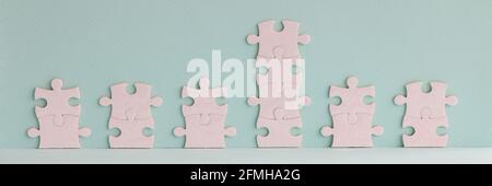 Weiße Puzzleteile liegen in Form eines Graphen auf blau Hintergrund Stockfoto