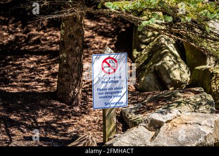 Rauchen verboten Symbol Schild, das besagt, dass es sich um ein rauchfreies Dorf mit ausgewiesener Raucherzone in Snowshoe, West Virginia kleinen Ski-Resort Stadt Stockfoto