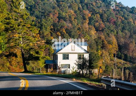 Bauernhaus am Straßenrand in ländlicher Straße in West Virginia durch Bergwald mit bunten Herbstbäumen Laub Bei Sonnenaufgang am Morgen Stockfoto