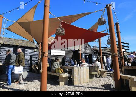 Menschen essen in der Sole Bay Fish Company, in der Frühlingssonne an der Southwold-Küste, in Suffolk, Großbritannien Stockfoto