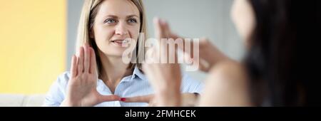 Zwei taube und stumme Frauen sprechen Gesten zu Hause Stockfoto