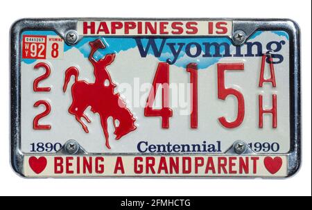 Altes Standard-Nummernschild aus Wyoming - Centennial Edition und Plattenrahmen mit dem Slogan „Happiness is being a granteltern“, 1990er Jahre Stockfoto