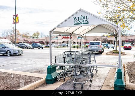 Reston, USA - 7. Dezember 2020: Whole Foods Market Parkplatz in Fairfax County Stadt im Winter mit Einkaufswagen und Schild für Michaels in stri Stockfoto