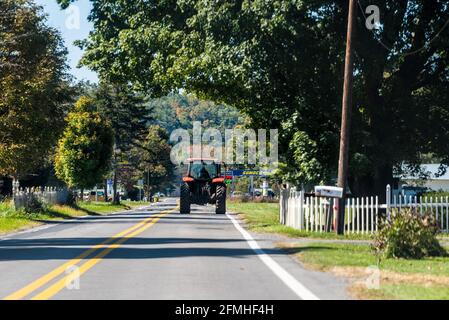 Green Bank, USA - 6. Oktober 2020: Bauerntraktor fährt auf asphaltierter Landstraße in der Stadt Green Bank kleines Wissenschaftsstädtchen in Wes Stockfoto