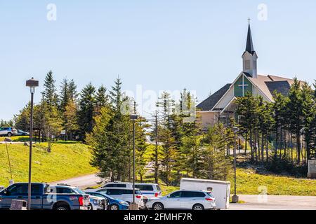 Snowshoe, USA - 6. Oktober 2020: St. Bernard Kapelle Holzkirche am Parkplatz mit Autos in einem kleinen Skiresort-Dorf in West Virginia Stockfoto