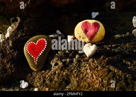 Herzförmige Korallen und Steine, bemalt mit leuchtend roten "Liebesherzen", in vulkanischen Felsen am Ufer des Sandy Beach Park, Oahu, Hawaii, USA platziert Stockfoto