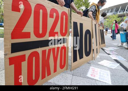 Tokio, Japan. Mai 2021. Anti-Olympia-Aktivisten halten Plakate, um gegen die Olympischen Spiele 2020 in Tokio zu protestieren Angesichts des Ausbruchs des neuen Coronavirus vor dem Nationalstadion, in dem sich eine Rennstrecke und ein Feld treffen, findet am Sonntag, dem 9. Mai 2021, in Tokio eine Testveranstaltung der Olympischen Spiele 2020 in Tokio statt. Quelle: Yoshio Tsunoda/AFLO/Alamy Live News Stockfoto