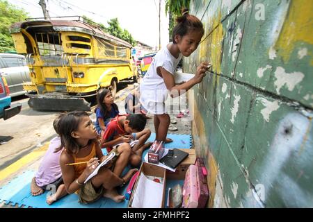 Diese Kinder haben den Bürgersteig in ein Klassenzimmer verwandelt, als sie eine Schulklasse entlang der Nepomuceno St. in Quiapo, Manila, verspotteten. Stockfoto