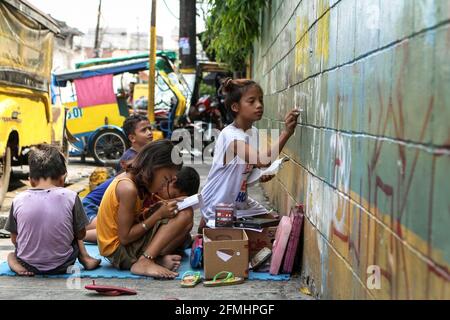 Diese Kinder haben den Bürgersteig in ein Klassenzimmer verwandelt, als sie eine Schulklasse entlang der Nepomuceno St. in Quiapo, Manila, verspotteten. Stockfoto