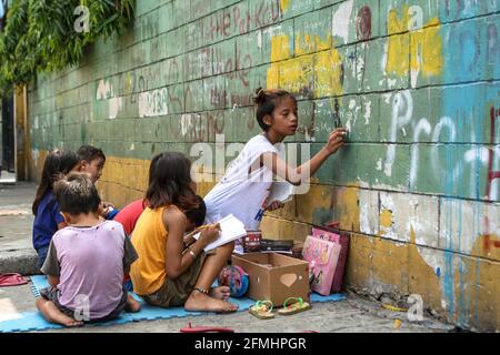 Diese Kinder haben den Bürgersteig in ein Klassenzimmer verwandelt, als sie eine Schulklasse entlang der Nepomuceno St. in Quiapo, Manila, verspotteten. Stockfoto