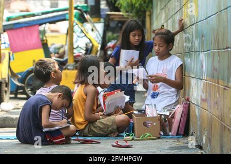 Diese Kinder haben den Bürgersteig in ein Klassenzimmer verwandelt, als sie eine Schulklasse entlang der Nepomuceno St. in Quiapo, Manila, verspotteten. Stockfoto