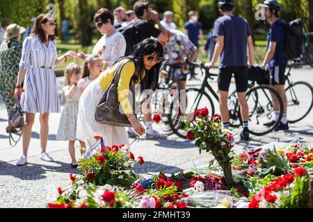 Berlin, Deutschland. Mai 2021. Am 9. Mai 2021, in Berlin, der Hauptstadt Deutschlands, legt eine Frau in der sowjetischen Gedenkstätte im Treptower Park Blumen aus Anlass des 76. Jahrestages des Endes des Zweiten Weltkriegs in Europa, bekannt als Tag des Sieges in Europa. Quelle: Stefan Zeitz/Xinhua/Alamy Live News Stockfoto