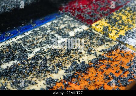 Vibrierende Sieb, Erzwäsche mit Flüssigkeit. Viele kleine Steine auf der Oberfläche des Siebes Stockfoto