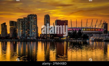Oranger Himmel vom Sonnenuntergang über dem BC Place und der Skyline von Vancouver Yale Town an der Nordküste von False Creek, British Columbia, Kanada Stockfoto