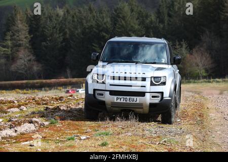 Ein neuer Land Rover Defender im Bild, der in Schottland, Großbritannien, über Land fährt. Stockfoto