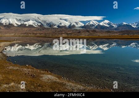 Pamir Berge spiegeln sich in Karakul See am Karakorum Highway, Provinz Xinjiang, China Stockfoto