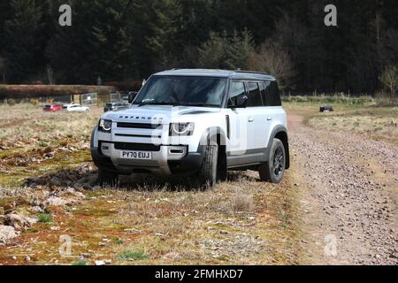 Ein neuer Land Rover Defender im Bild, der in Schottland, Großbritannien, über Land fährt. Stockfoto