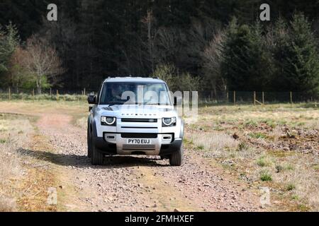 Ein neuer Land Rover Defender im Bild, der in Schottland, Großbritannien, über Land fährt. Stockfoto