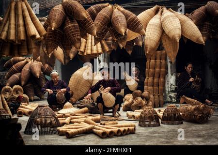 Handwerker, der im alten Dorf Hung Yen, Vietnam, Bambusfischfalle herstellte Stockfoto