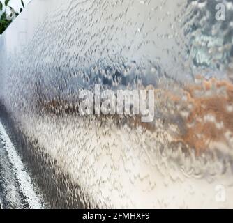 Fallende Wasserstruktur über Wandhintergrund in hoher Auflösung Stockfoto
