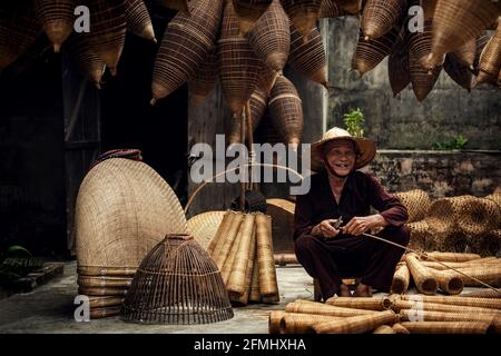 Handwerker, der im alten Dorf Hung Yen, Vietnam, Bambusfischfalle herstellte Stockfoto