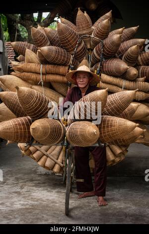 Handwerker, der im alten Dorf Hung Yen, Vietnam, Bambusfischfalle herstellte Stockfoto