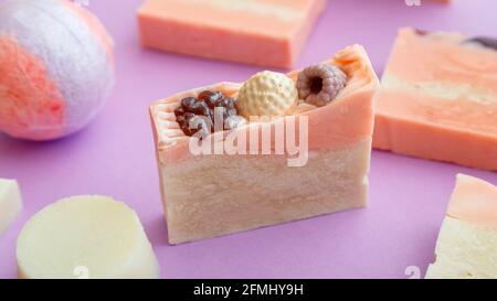 Natürliches handgemachtes Seifenstück. Viele duftende handgemachte Spa Bio rosa Seifenstücke. Hausgemachte Beauty-Bad-Produkte auf violettem Hintergrund. Hygieneartikel Stockfoto