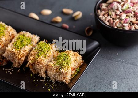 Türkisches tel Kadayif Dessert aus geschreddertem Phyllo-Teig, gemischt mit Walnüssen. Es wird mit dickem Sirup gesüßt und gemahlene Pistazien werden darüber hinzugefügt Stockfoto