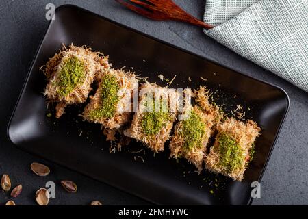 Türkisches tel Kadayif Dessert aus geschreddertem Phyllo-Teig, gemischt mit Walnüssen. Es wird mit dickem Sirup gesüßt und gemahlene Pistazien werden darüber hinzugefügt Stockfoto