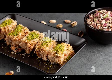 Türkisches tel Kadayif Dessert aus geschreddertem Phyllo-Teig, gemischt mit Walnüssen. Es wird mit dickem Sirup gesüßt und gemahlene Pistazien werden darüber hinzugefügt Stockfoto