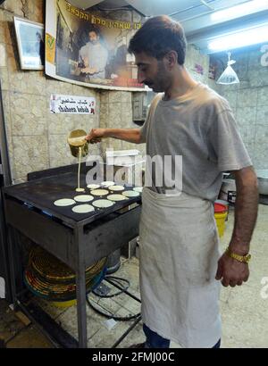 Ein Mann aus Palästina, der Atayef (Qatayef) zubereitet - EIN traditionelles Dessert Beliebt während des heiligen Monats Ramadan und besonders während Eid Al Fitr Urlaub Stockfoto