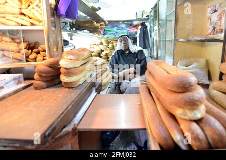 Ein Palästinenser, der Ka'ak-Brot aus seinem kleinen Laden im muslimischen Qt. In der Altstadt von Jerusalem verkauft. Stockfoto