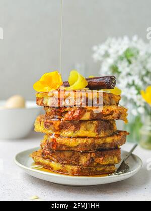 Ein Haufen süßer französischer Toasts, die mit Honig gegossen wurden, serviert Auf dem Teller zum Frühstück in der Küche Stockfoto