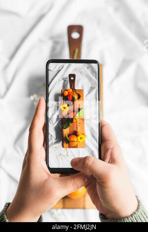 Weibliche Angestellte in formeller Kleidung, die in die Kamera schaut, während sie in der Nähe einer Gruppe von mehrrassischen männlichen Kollegen in einem hellen modernen Büro steht Stockfoto