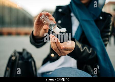 Crop unkenntlich muslimische Frau in Hijab Anwendung antibakterielle Desinfektionsmittel auf Hände während einer Coronavirus-Pandemie auf der Straße der Stadt Stockfoto