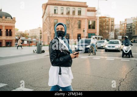 Seitenansicht der fokussierten schwarzen Athletin in Sportswear tun Übungen beim Dehnen und Aufwärmen der Beine in der Stadt Stockfoto